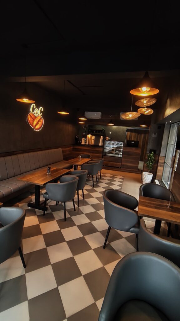 Seating area with a checkered floor at Coffee@Cafe Ambur