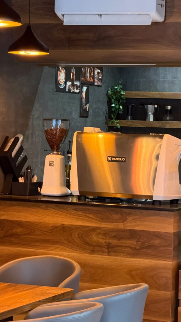 Grinder and espresso machine on the wooden bar at Coffee@Cafe Ambur