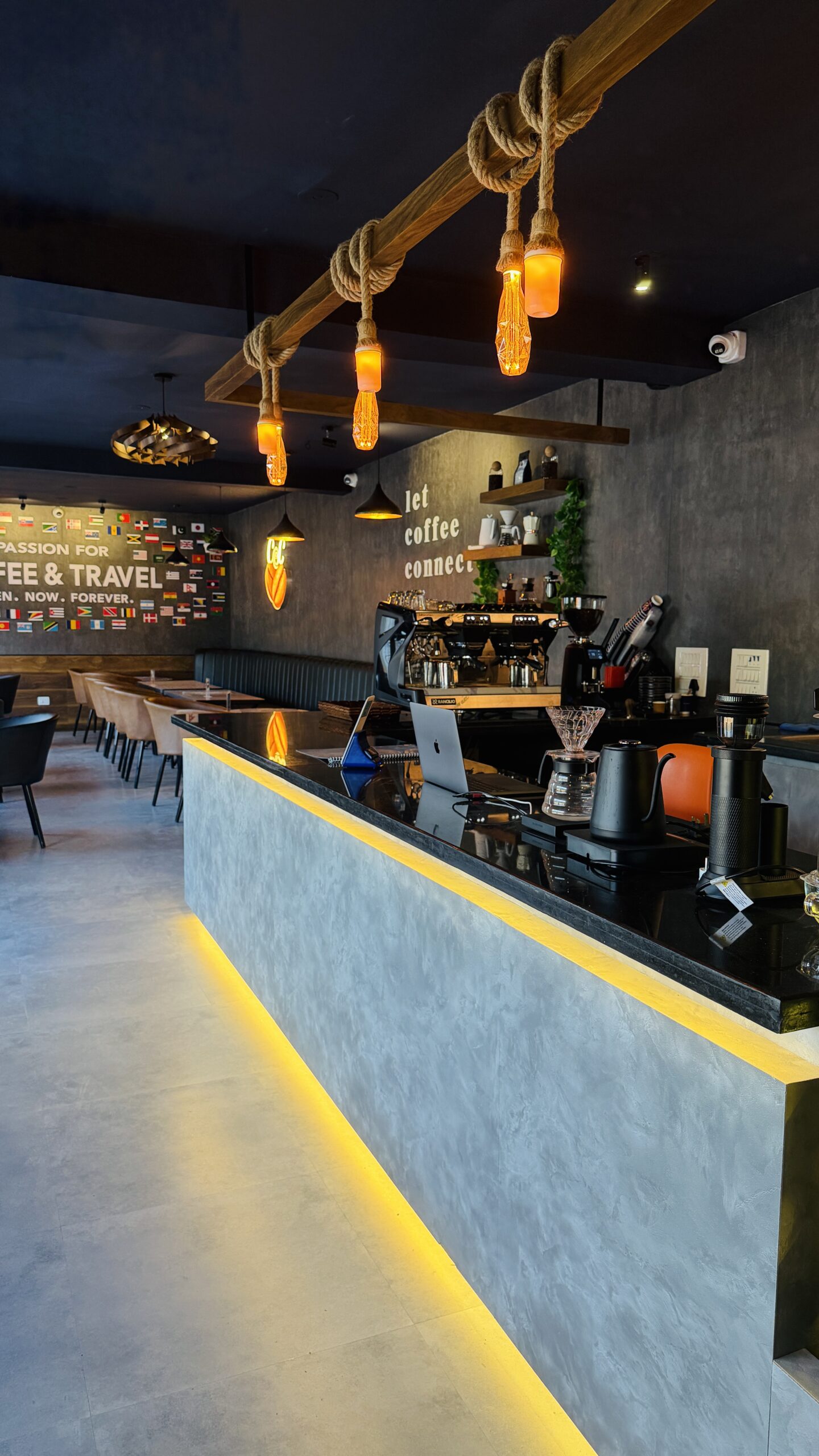 Lit counter with seating and the flag wall behind at Coffee@Cafe Vaniyambadi