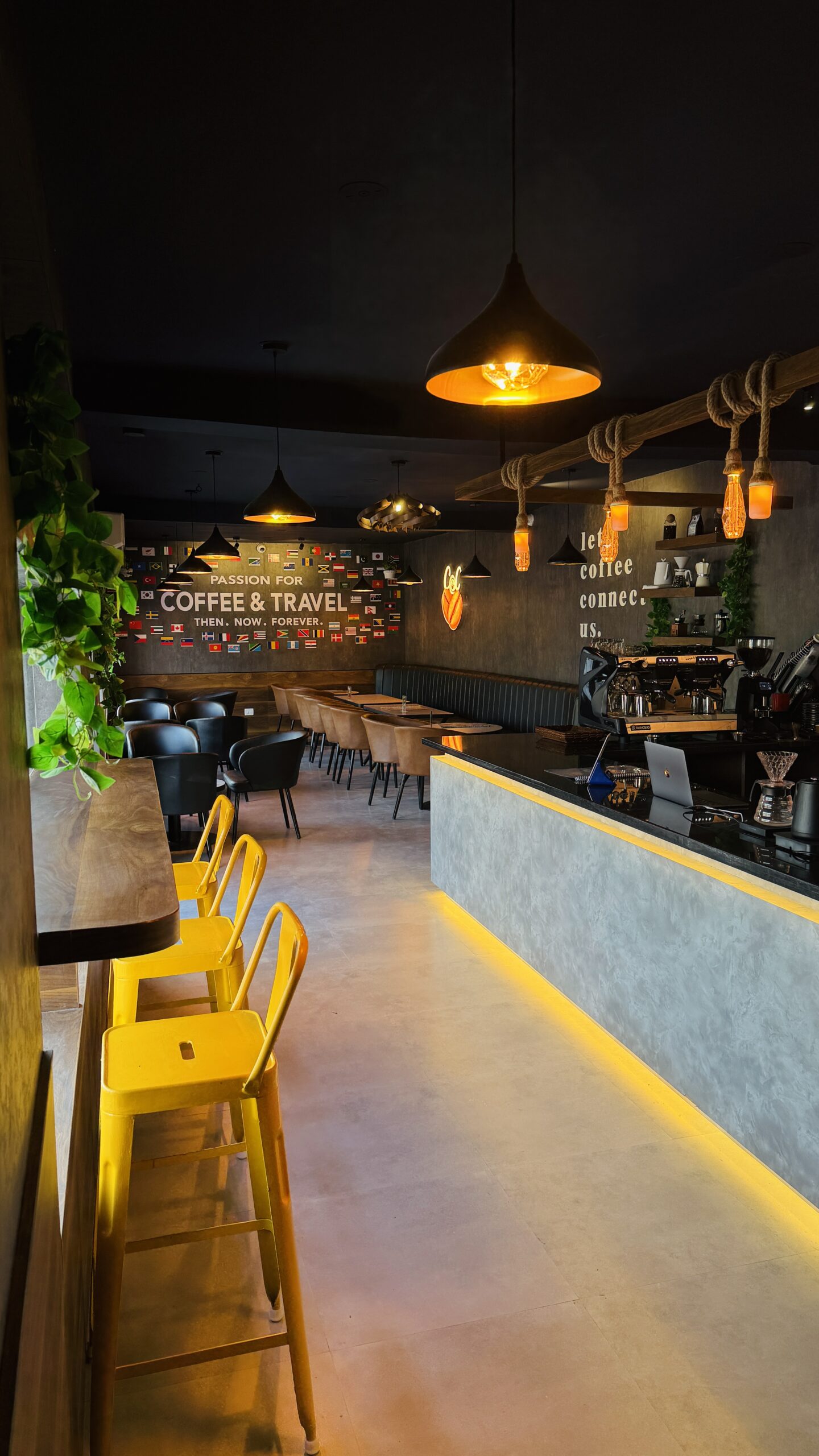 Coffee@Cafe Vaniyambadi interior with yellow stools, the counter and the flag wall